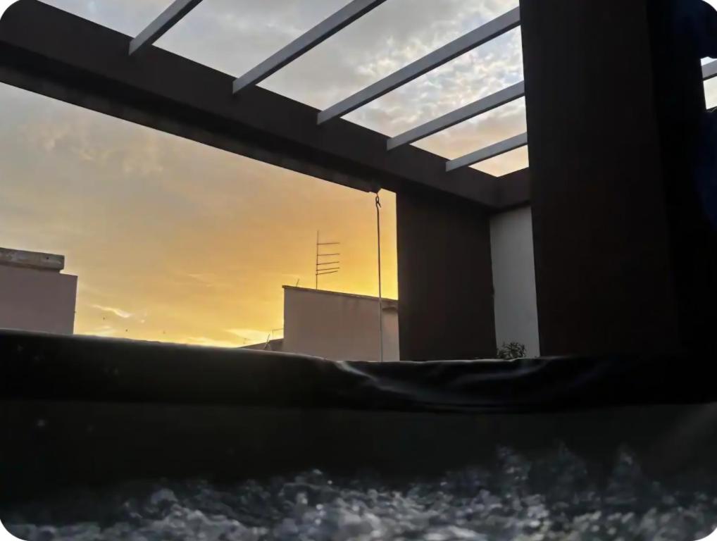 a sunset seen through a window of a building at Attico Casa ReGa - private parking and bbq in Quartu Sant'Elena