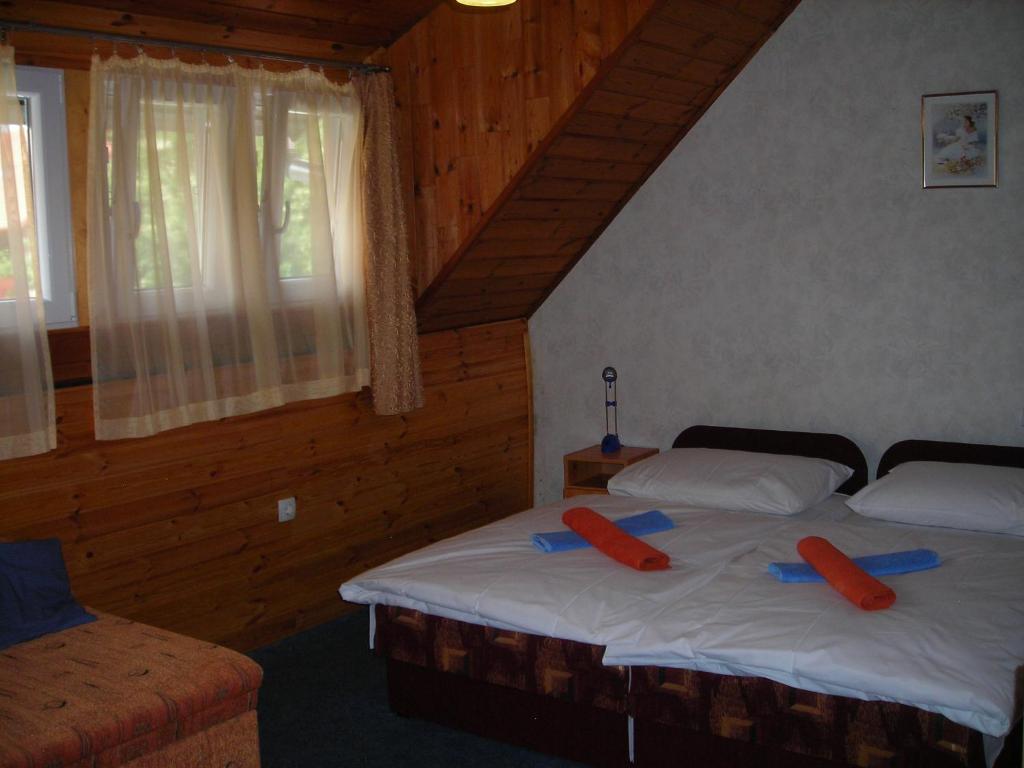 um quarto com 2 camas com almofadas vermelhas em Al Do Apartman em Bük