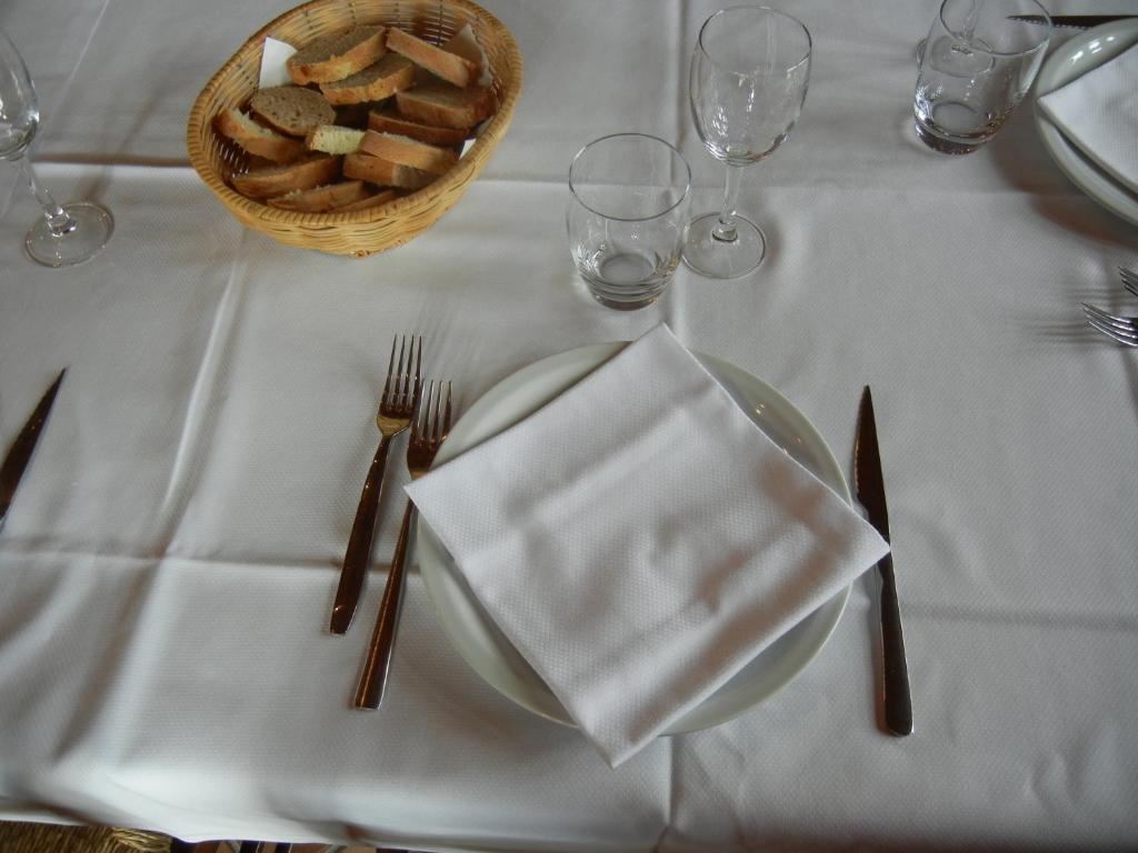 una mesa con un plato de comida y una cesta de pan en La Colombarola, en Farneto