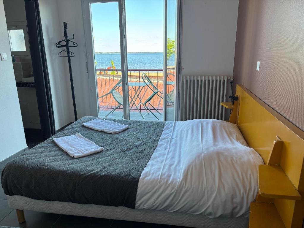 a bedroom with a bed with a view of the ocean at Le Moutchico in Lacanau