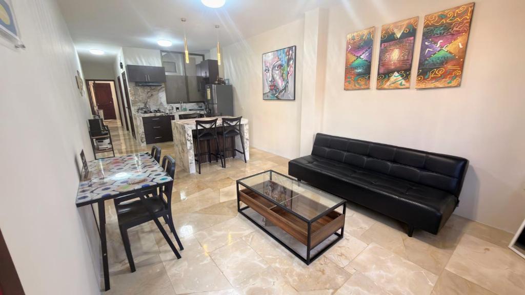 a living room with a black couch and a table at NCG Suite in Guayaquil