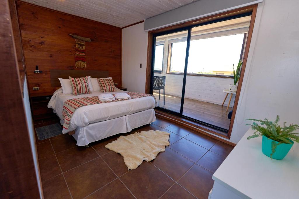 a bedroom with a bed and a large window at Pichilemu Apart Hotel in Pichilemu