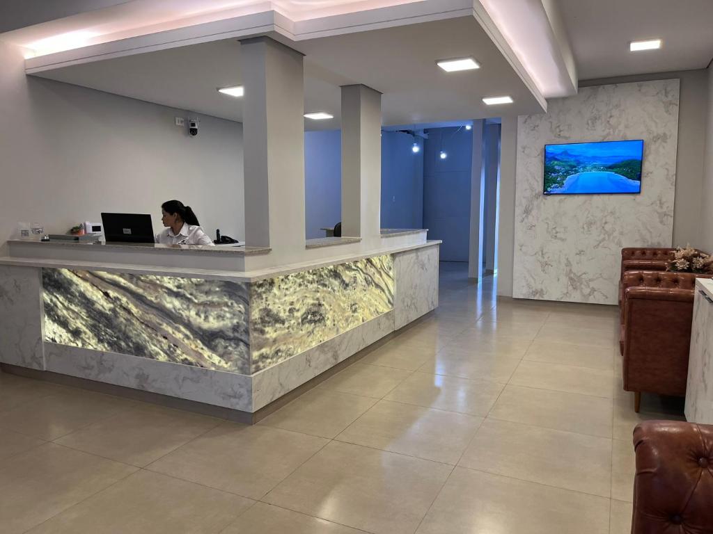 a woman sitting at a reception desk with a laptop at Rosa's Hotel in Toledo