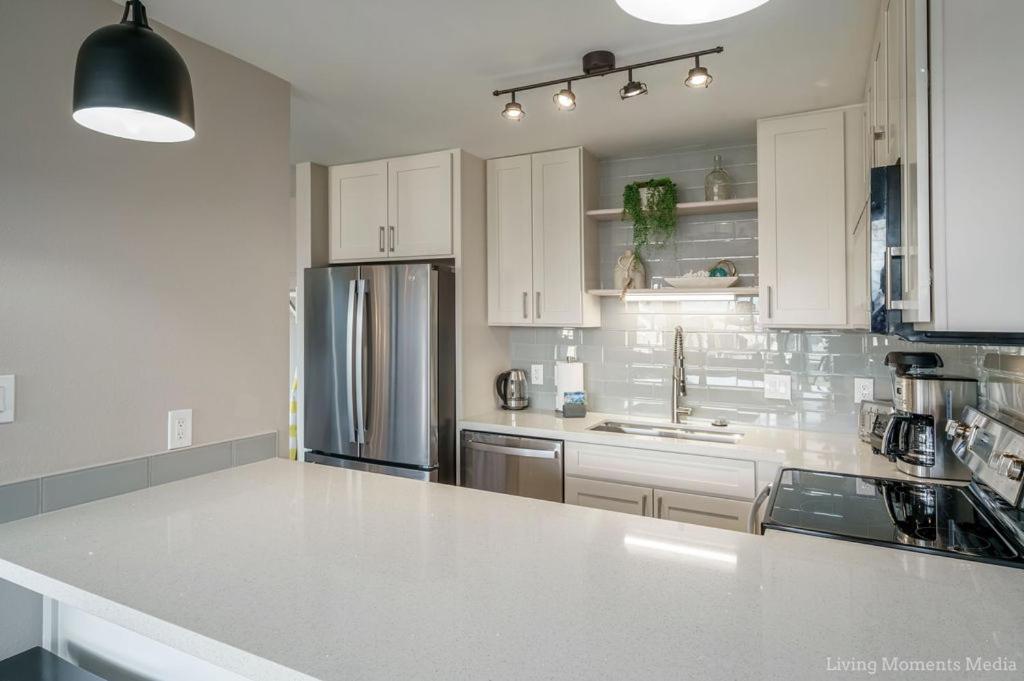 a kitchen with white cabinets and a stainless steel refrigerator at 214 Kihei Holiday in Kihei