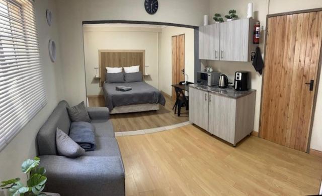 a living room with a couch and a bed and a kitchen at 26onMagazyn in Polokwane