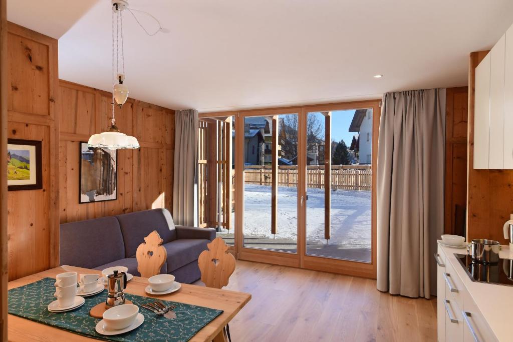 eine Küche und ein Wohnzimmer mit einem Sofa und einem Tisch in der Unterkunft Residence Simml & Schlosser in Innichen
