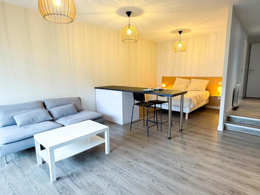 a living room with a couch and a table at Volcania Suites in Clermont-Ferrand