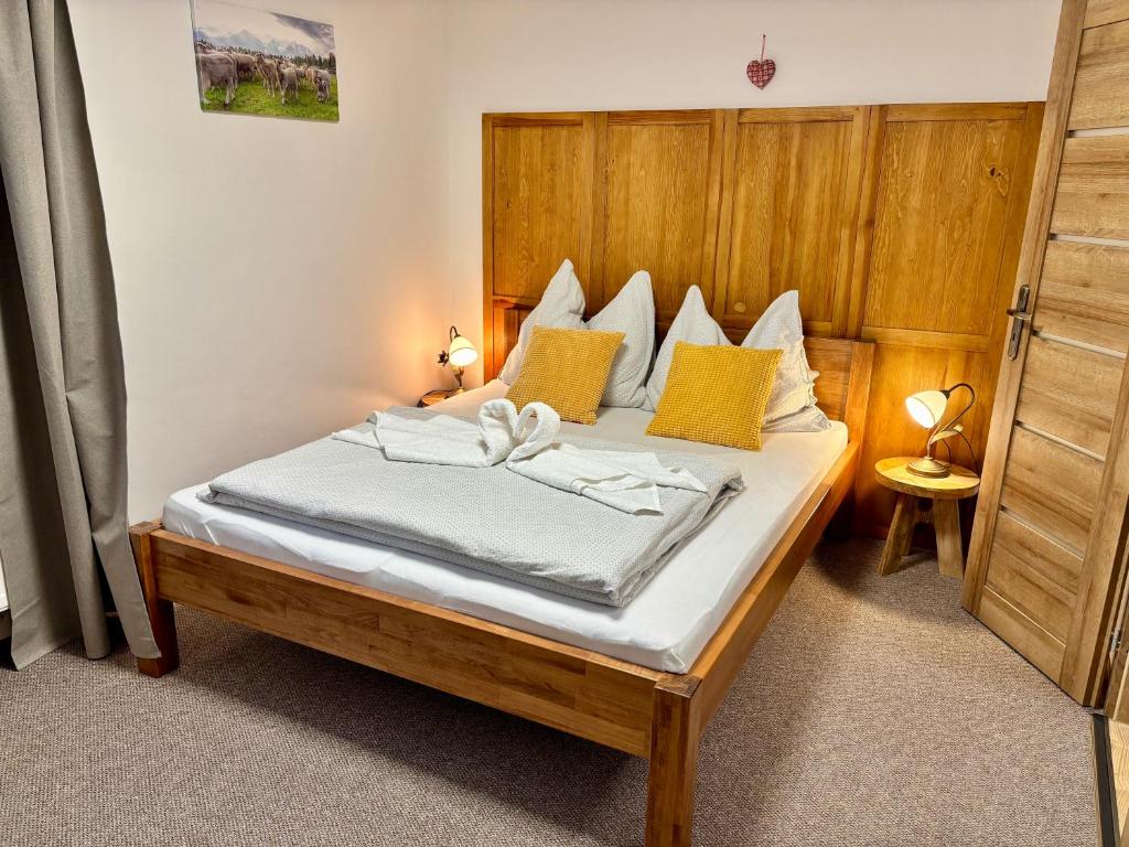 a bedroom with a large bed with yellow pillows at Villa Slnecnica in Nová Lesná