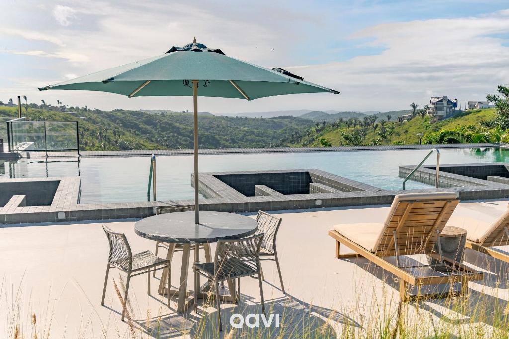 a table and chairs with an umbrella on a patio at Casa de Alto Padrão na Serra de Bananeiras by Qavi in Bananeiras