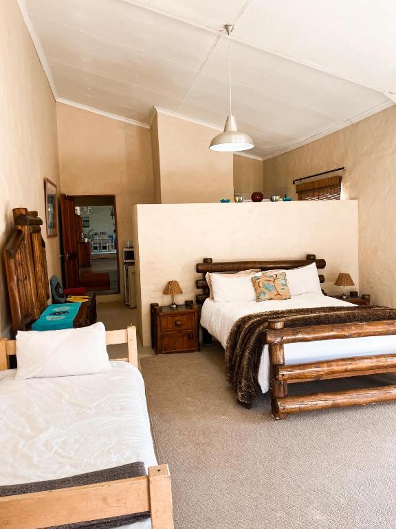 a bedroom with two beds and a mirror at Esperanza Wood Room in George