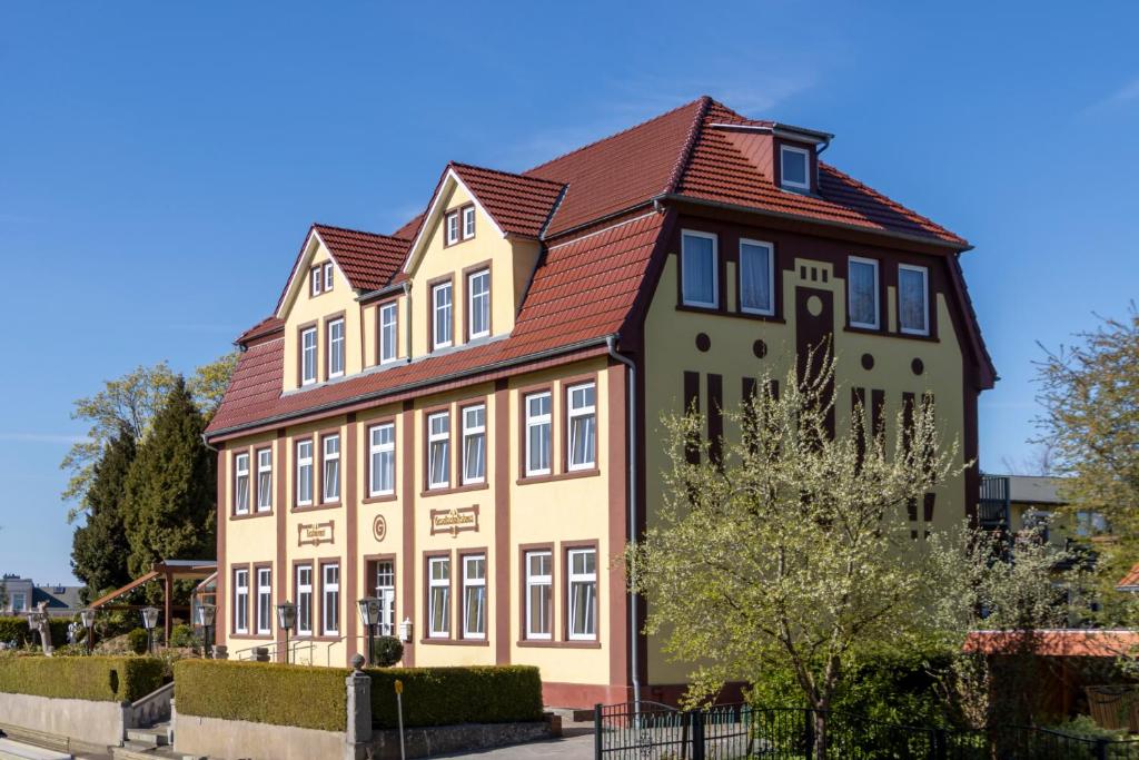 a large house with a red roof at Hotel Gesellschaftshaus in Bergen auf Rügen