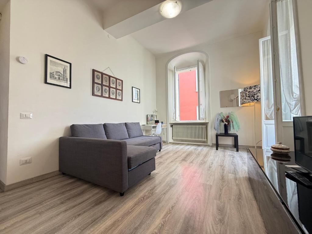a living room with a couch and a tv at LA VIOLETTA DI PARMA // DEL DUCATO in Parma
