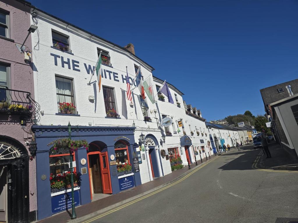 a white building with a sign on it on a street at The White House in Kinsale