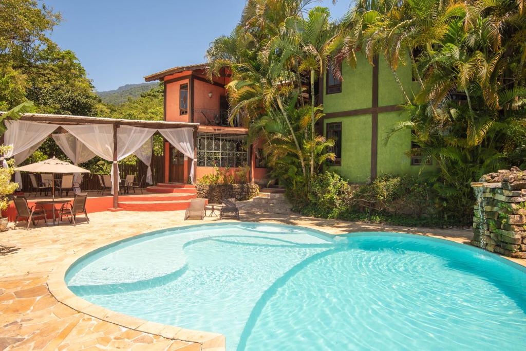 a swimming pool in front of a house at Pousada Villaggio Assis in Ilhabela