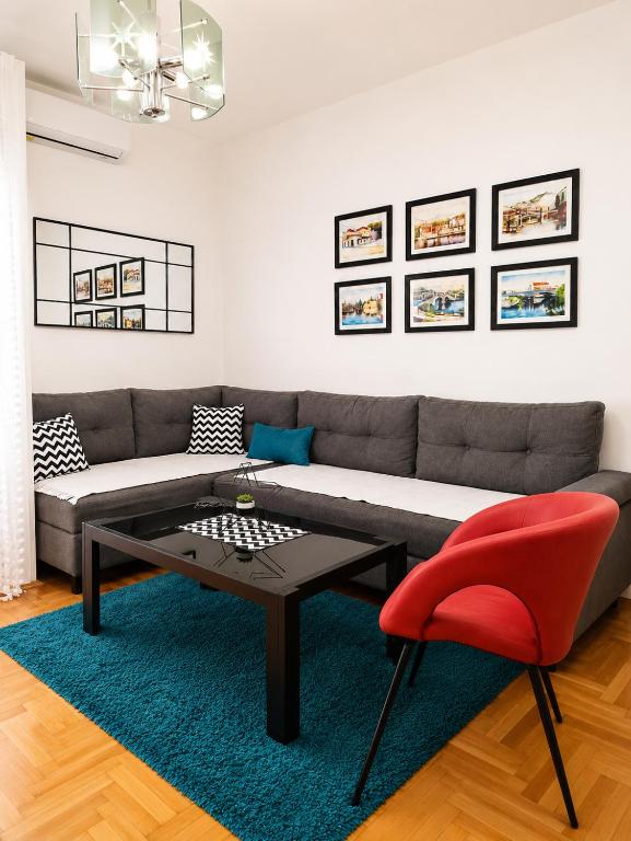 a living room with a couch and a table and a red chair at Agape C-52 in Trebinje