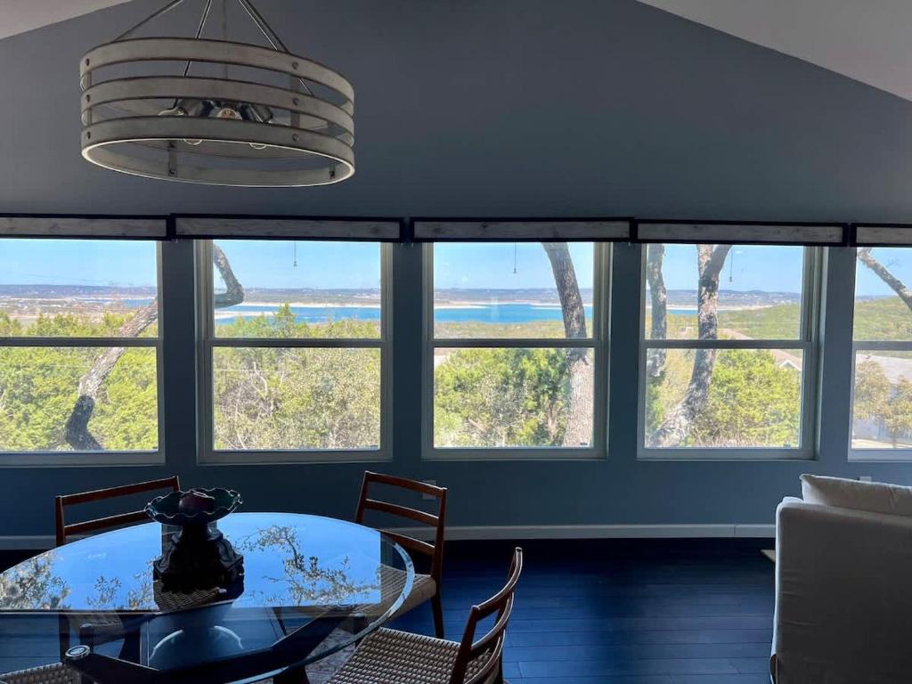 a dining room with a table and a bunch of windows at Canyon Lake House with Lake View in Canyon Lake