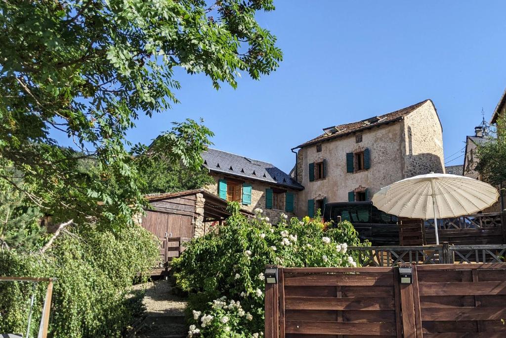 an umbrella in a garden next to a building at La Ferme Des Astres in Les Angles