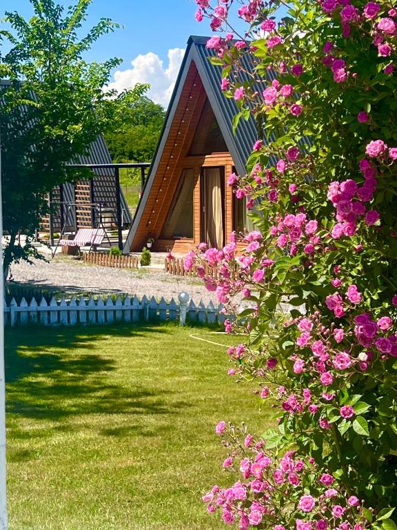 a small house with pink flowers in front of it at Narnia Cottages in Bazalet'i