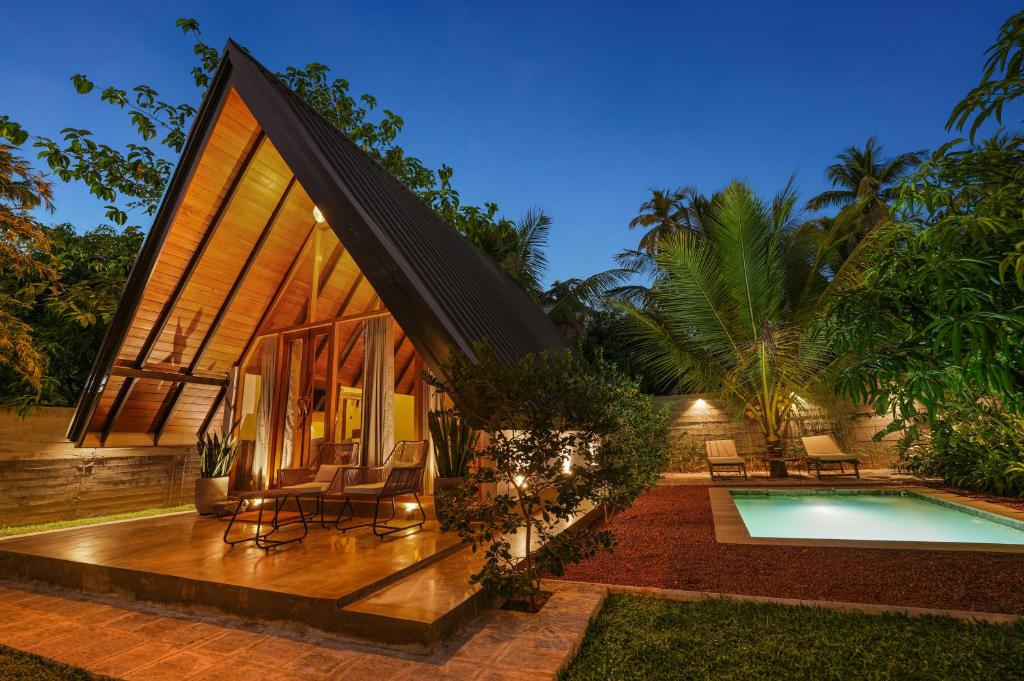 a villa with a swimming pool at night at Aalanga Escape by Lush Villa in Kanugala