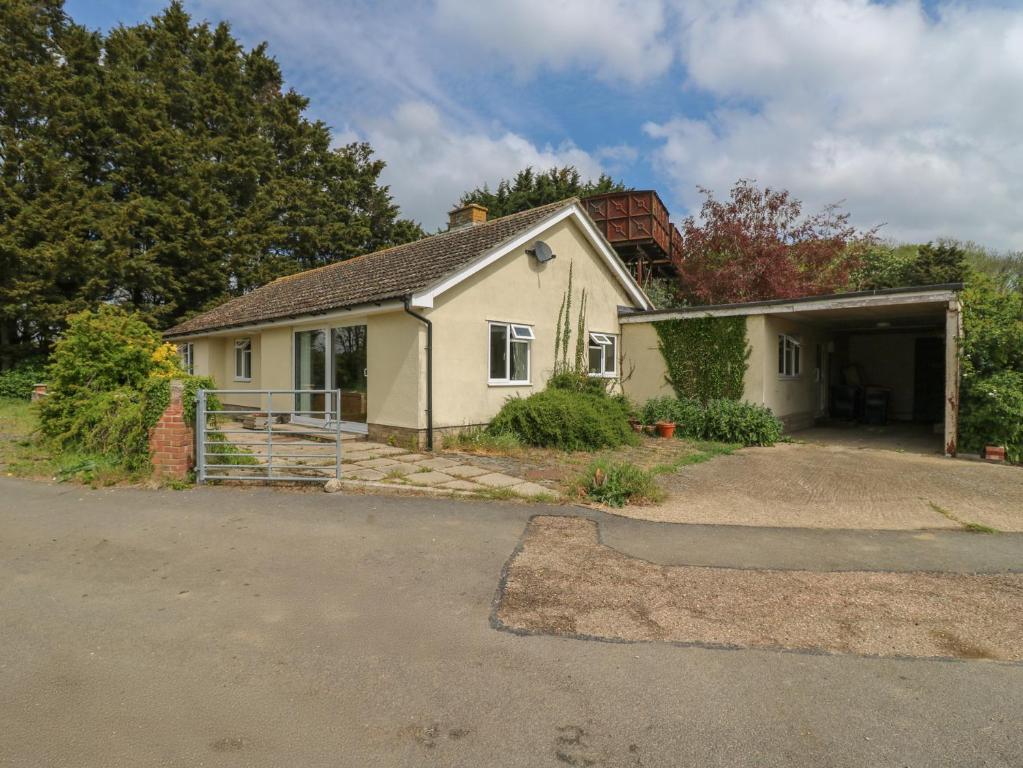 a small house with a garage in a driveway at The Lodge in Colchester
