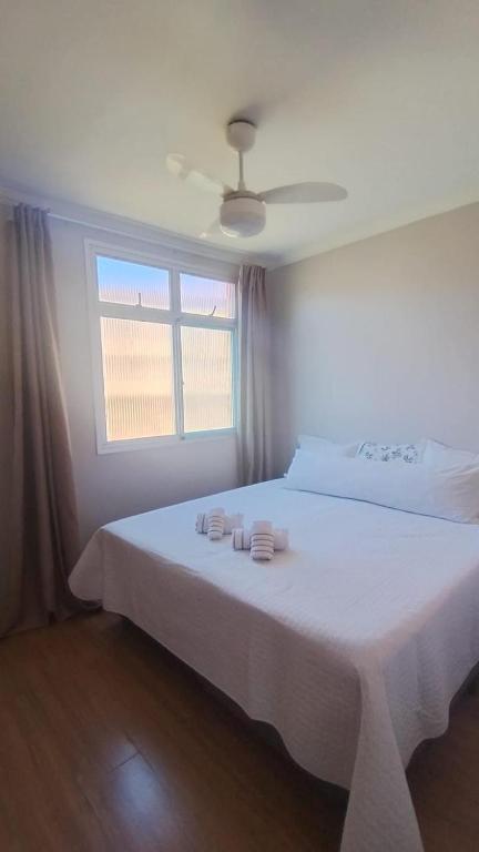 a bedroom with a bed with white sheets and a window at Refúgio da praia in Serra