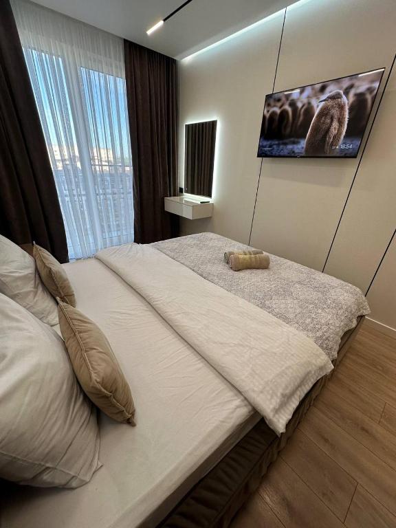 a bedroom with a large bed with a tv on the wall at Euroconfort Ciocana Apartment Exfactor 6 in Chişinău