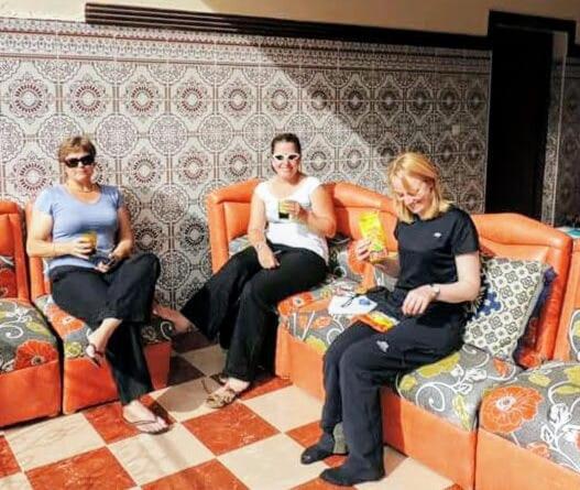 three people sitting on orange chairs in a room at Atlas Rooftop Imlil in Imlil