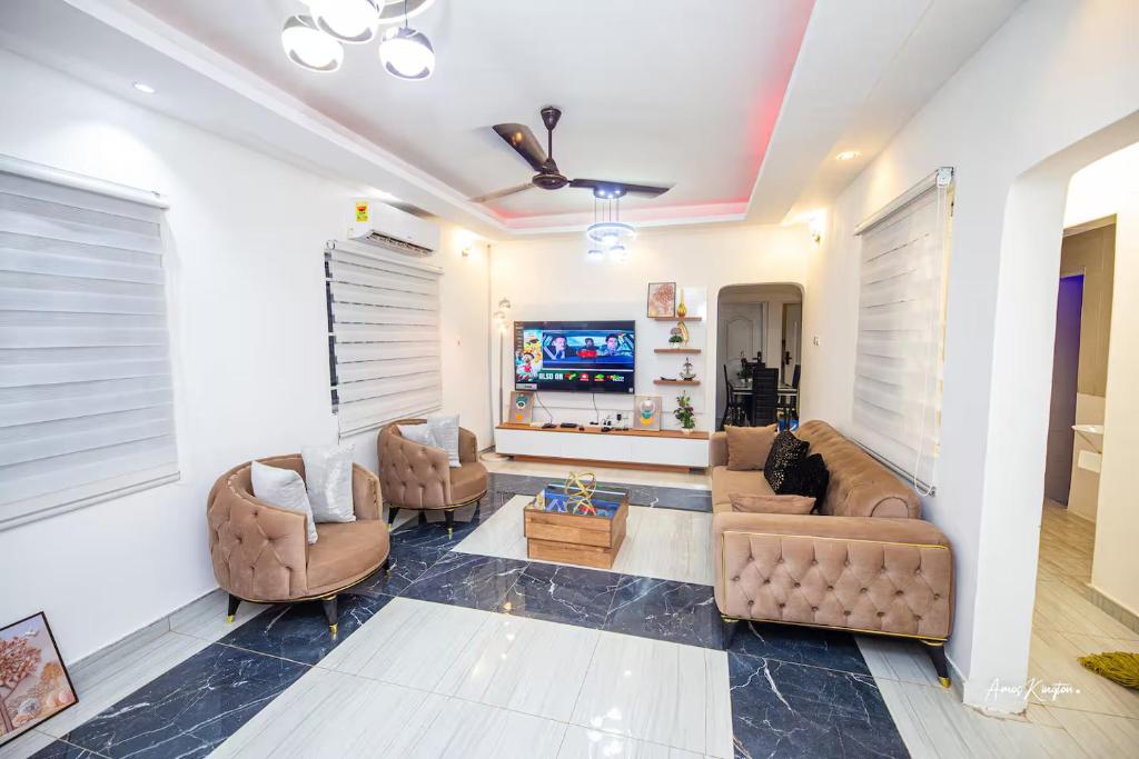 a living room with two couches and a tv at Eljay Luxury Stay in Ashalebotwe