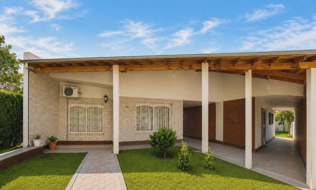 a house with a porch with a green lawn at Casa TiaMaria - Centro San Rafael in San Rafael