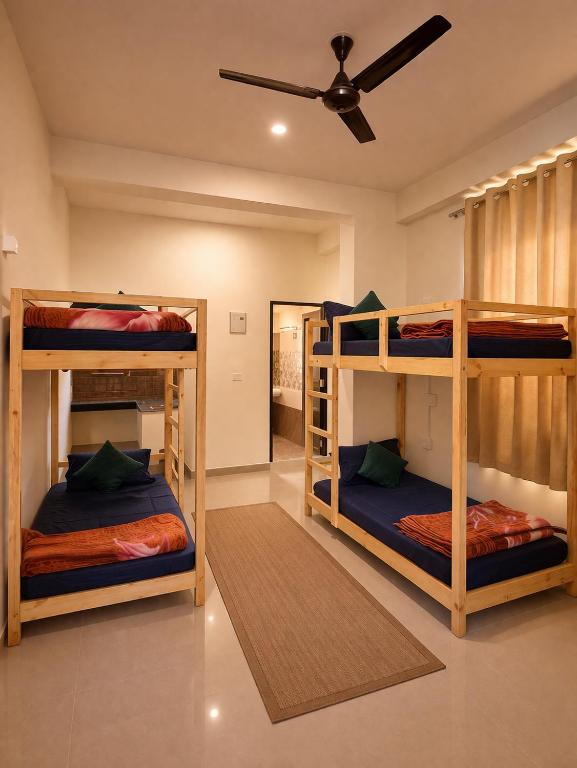 three bunk beds in a room with a ceiling at LVMR DORMS MOHAL Bhuntar in Shamshi