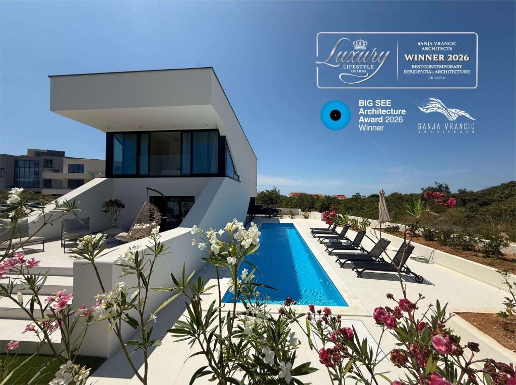 a villa with a swimming pool and lounge chairs at Villa Lunga Novalja in Novalja
