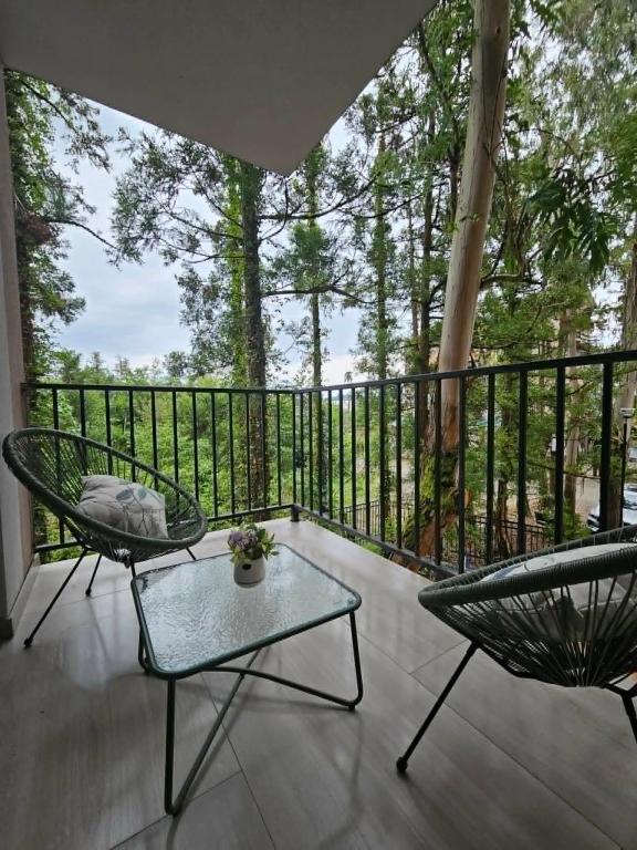 a patio with two chairs and a table on a balcony at Sun Estate Ureki in Ureki