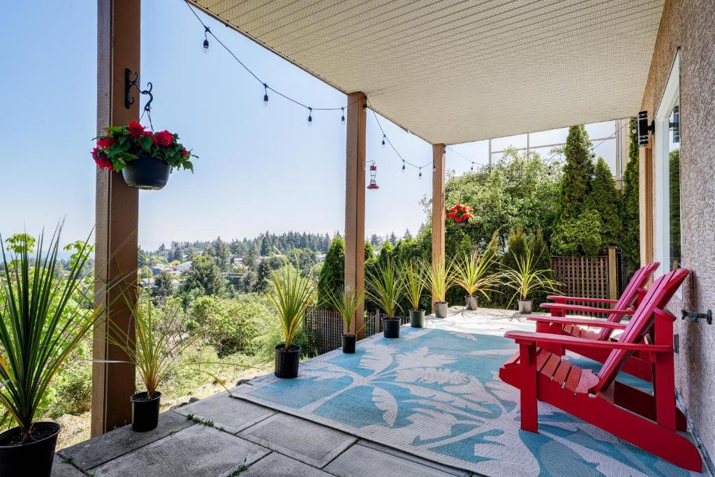 a patio with a red bench and plants at Ravenwood Stay With Ocean View in Victoria