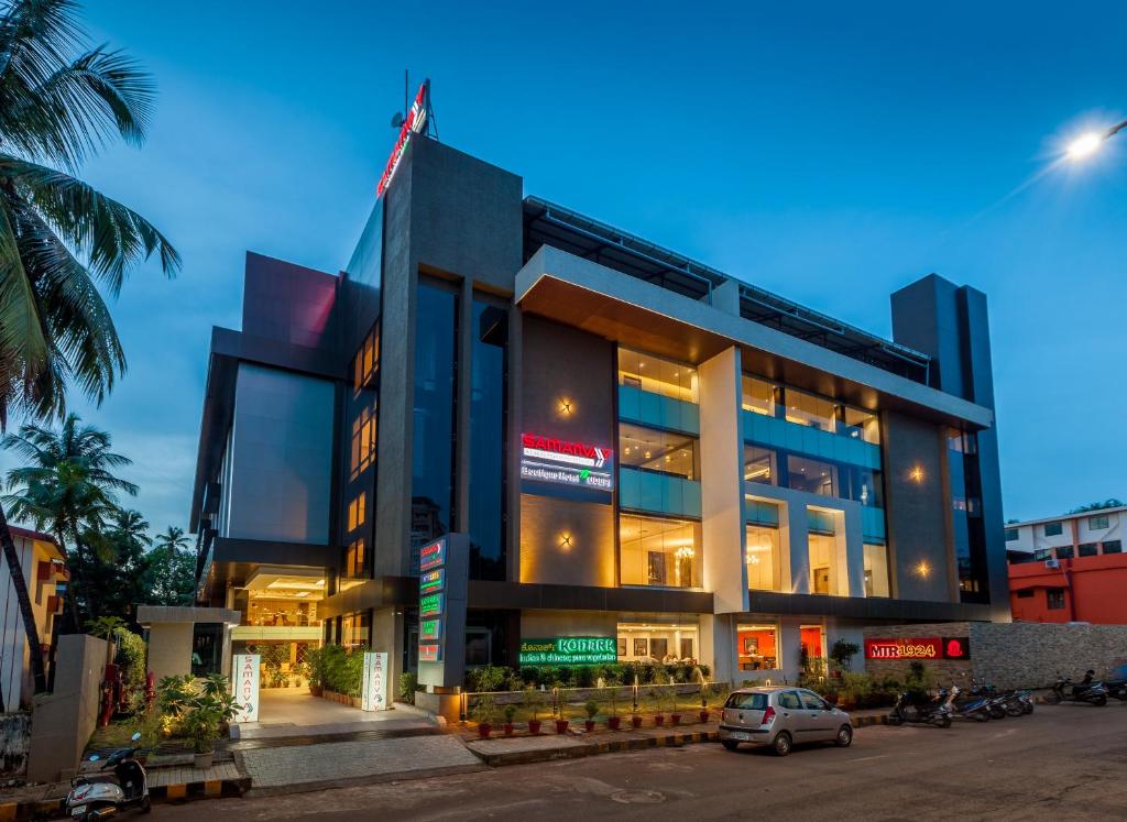 um edifício com um carro estacionado em frente em Samanvay Boutique Hotel em Udupi