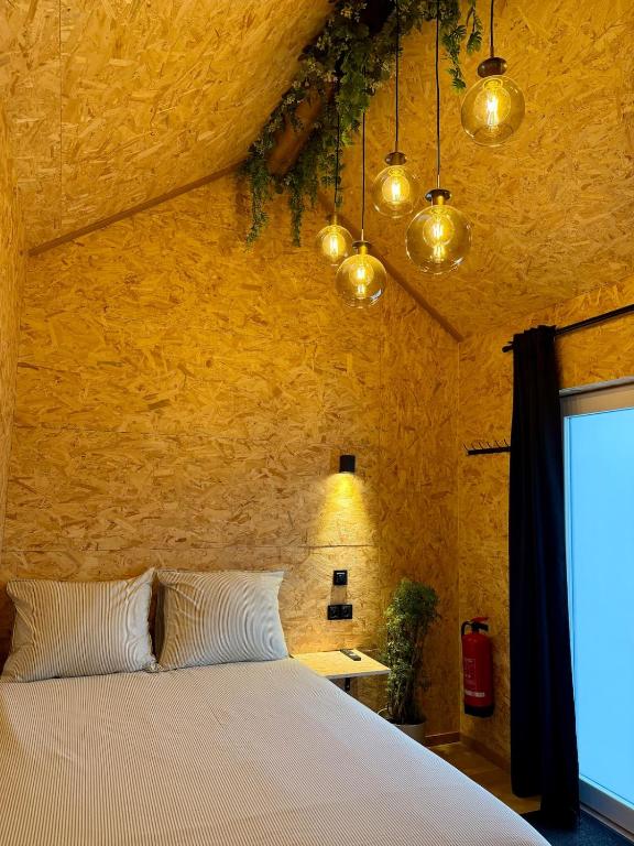 a bedroom with a bed in a stone wall at Petite maison village fruitier in Gingelom