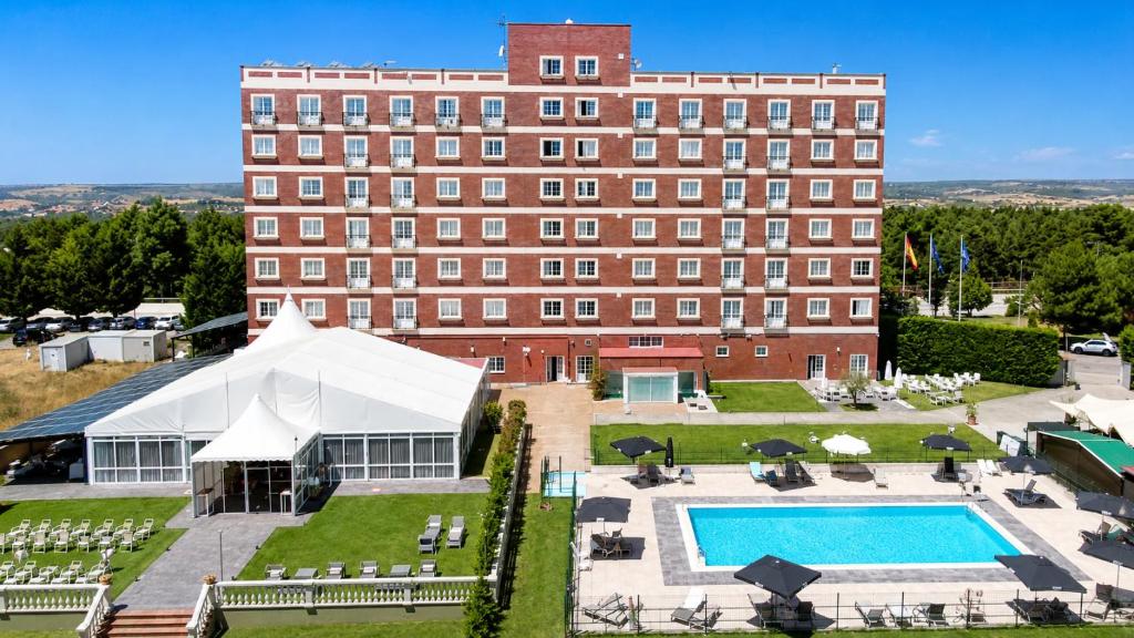 a hotel with a pool and a building at ARVA Santiago León in León