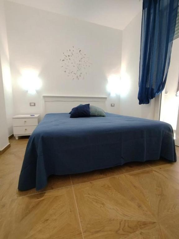 a bedroom with a bed with a blue blanket at Turquoise Horizon in Stintino
