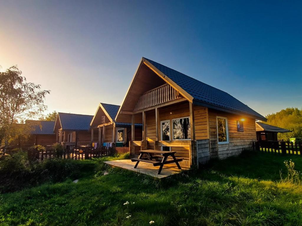 a log cabin with a picnic table in front of it at Osada Kryspinów in Cholerzyn