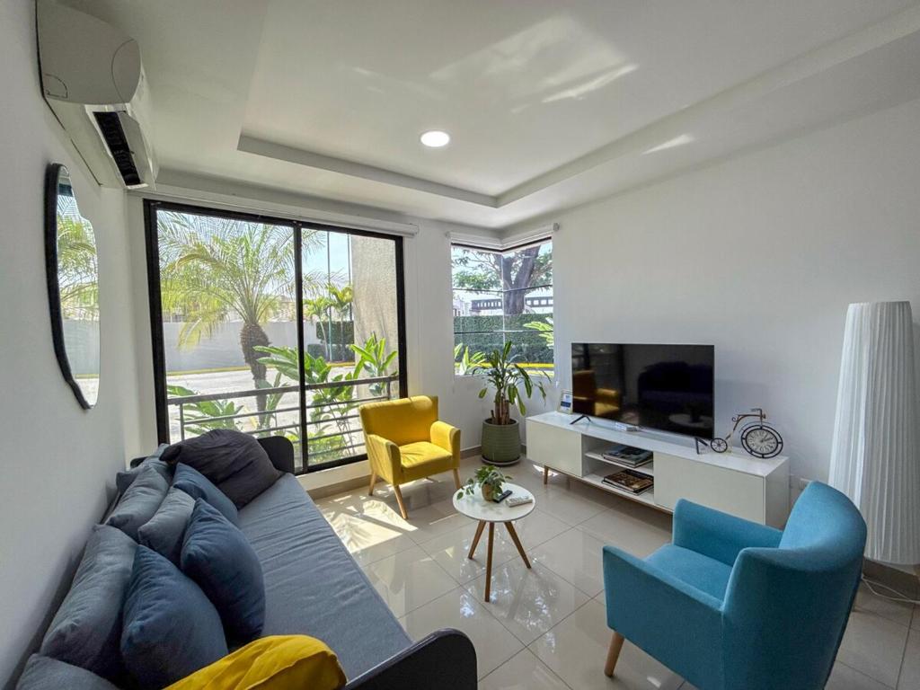 a living room with a couch and chairs and a tv at Nice and Modern Apartment, Parking in SamborondÃ³n