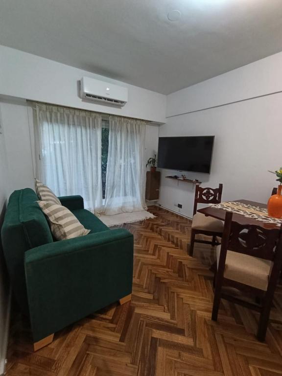 a living room with a green couch and a table at alma in Buenos Aires