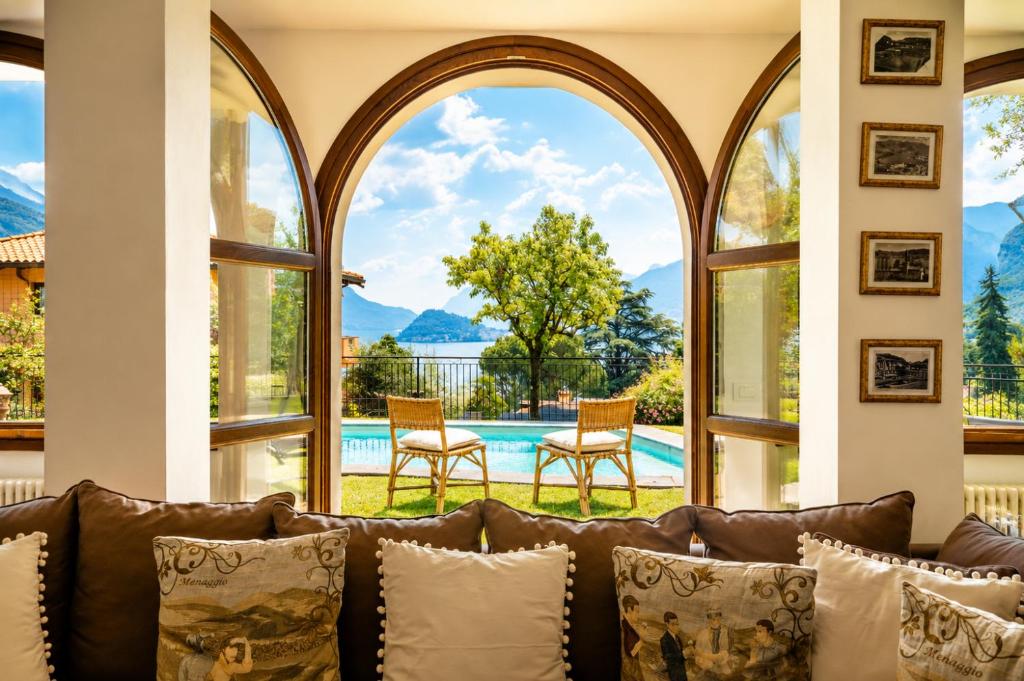 a living room with a couch and large windows at Villa Le Rose, Menaggio in Menaggio