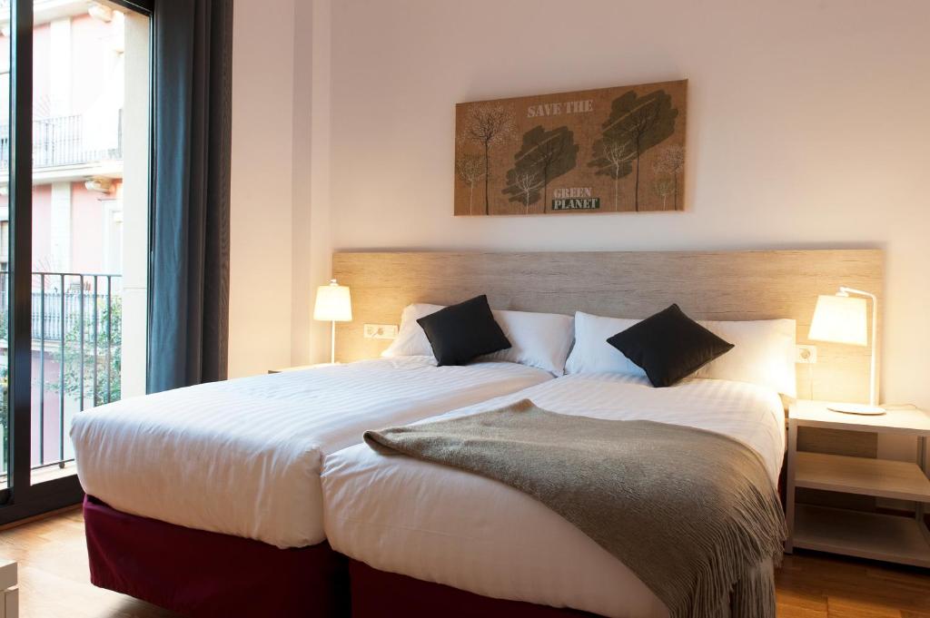 um quarto com uma cama grande e uma janela grande em MH Apartments Gracia em Barcelona