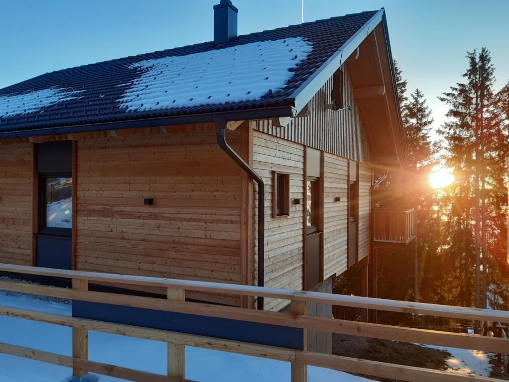 a log cabin with a snow covered roof at Wellness Chalet Zirbitz in Lavantegg