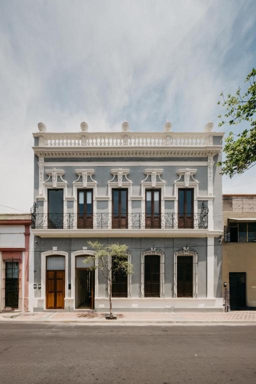 a large white building with windows on a street at Calle y Número, San Felipe in Guadalajara