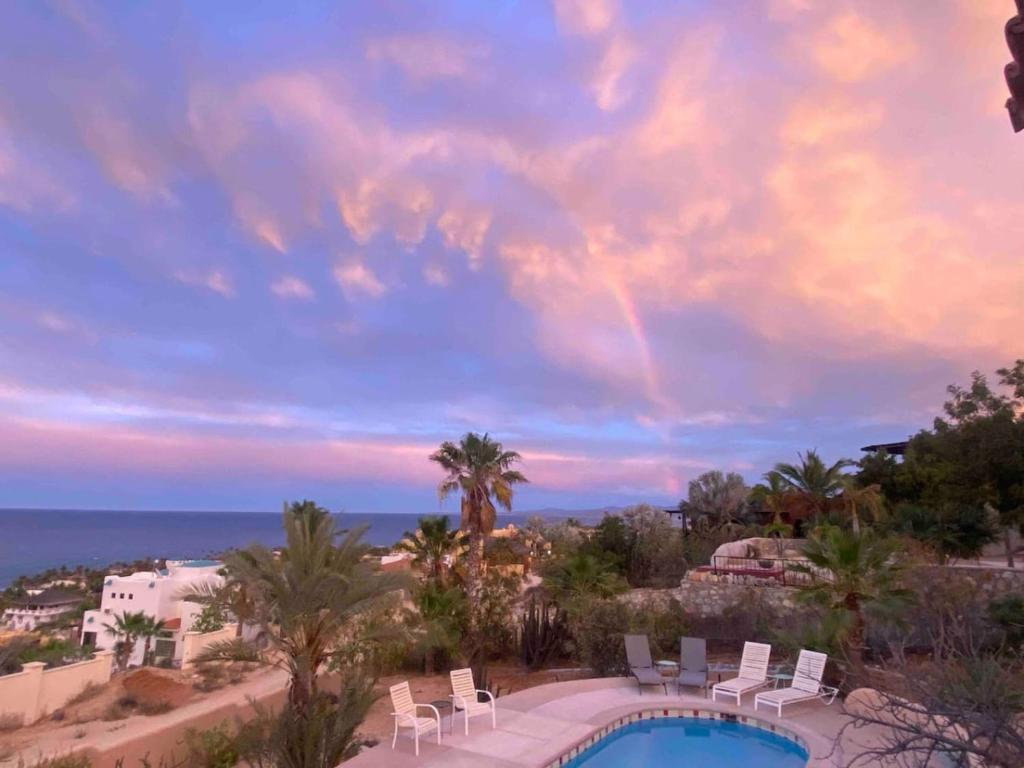 a view of a pool and chairs and the ocean at Home With Private Pool Ocean and Mountain Views in Los Barriles
