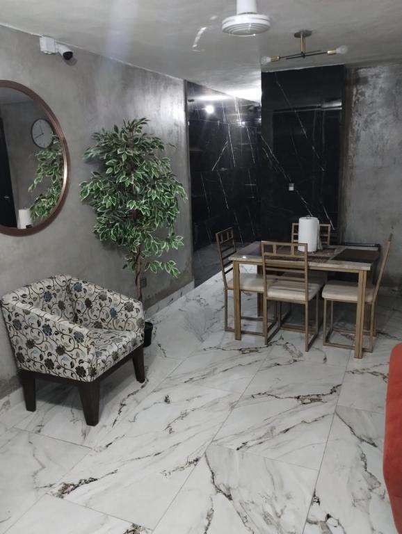 a dining room with a table and chairs on a marble floor at Casa Rota in Mérida