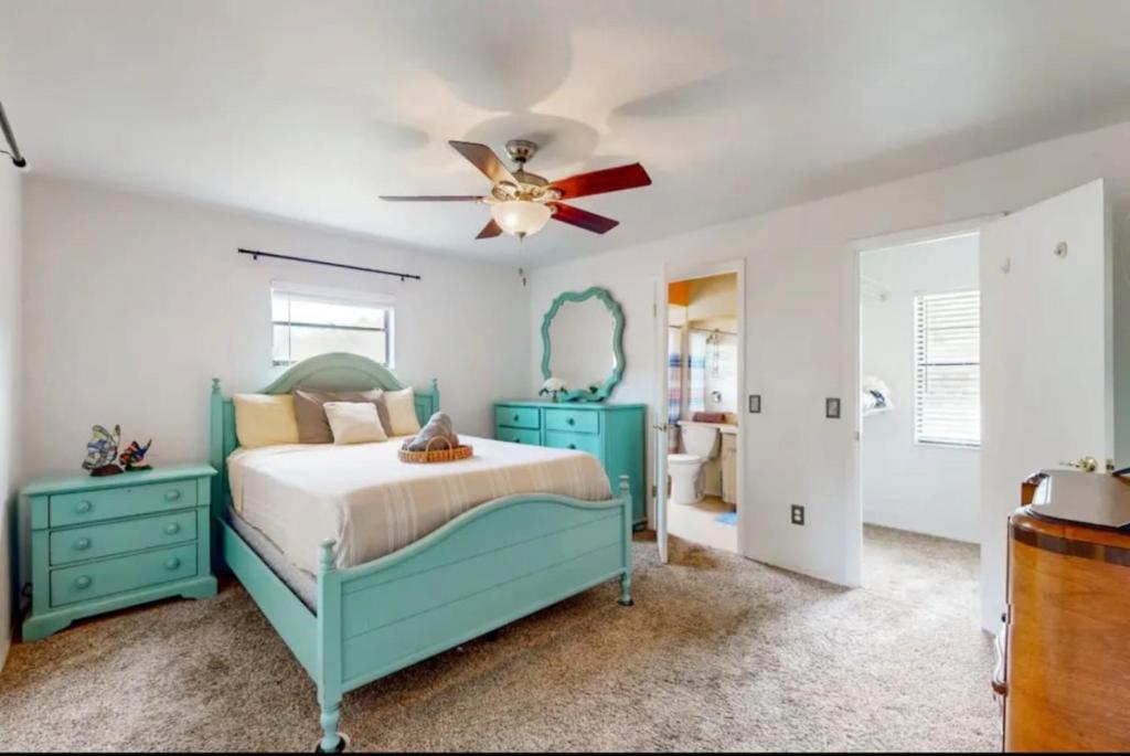 a bedroom with a blue bed and a ceiling fan at Sunset Oasis (Homosassa Springs) in Homosassa