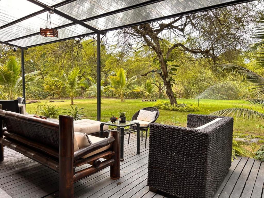 a patio with a couch and chairs on a deck at Rio Olón ecolodge in Olón