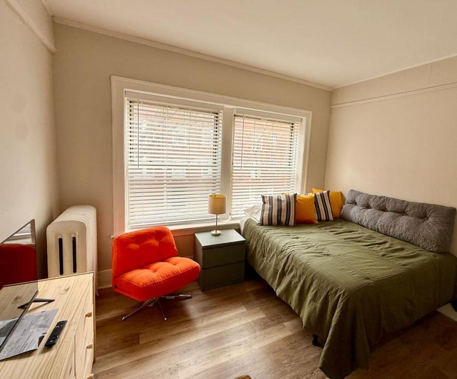a bedroom with a bed and a chair and a window at Well Located Studio on the Red Line in Chicago