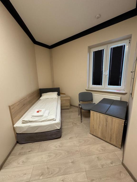 a small room with a bed and a chair at Motel Okoń in Orzysz